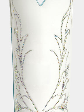 Close-up of a white western-style boot or boot shaft decorated with intricate silver rhinestone embroidery and small iridescent accents.