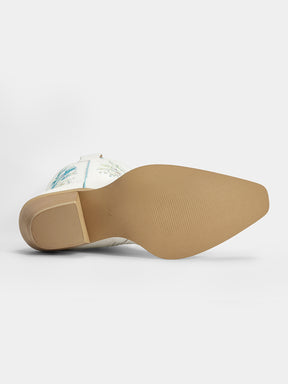 A cowboy boot shown from a side-rear angle, displaying its tan outsole and a white leather shaft with light blue floral embroidery, set against a plain light gray background.