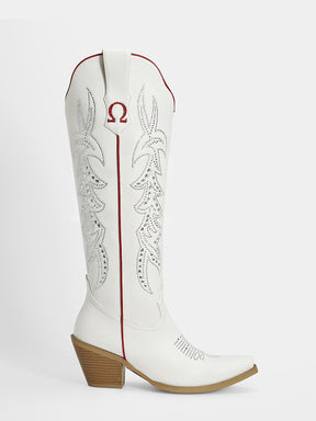 A white leather cowboy boot with red stitching, a red embroidered Omega symbol on the shaft, and a brown stacked block heel, shown against a light gray background.