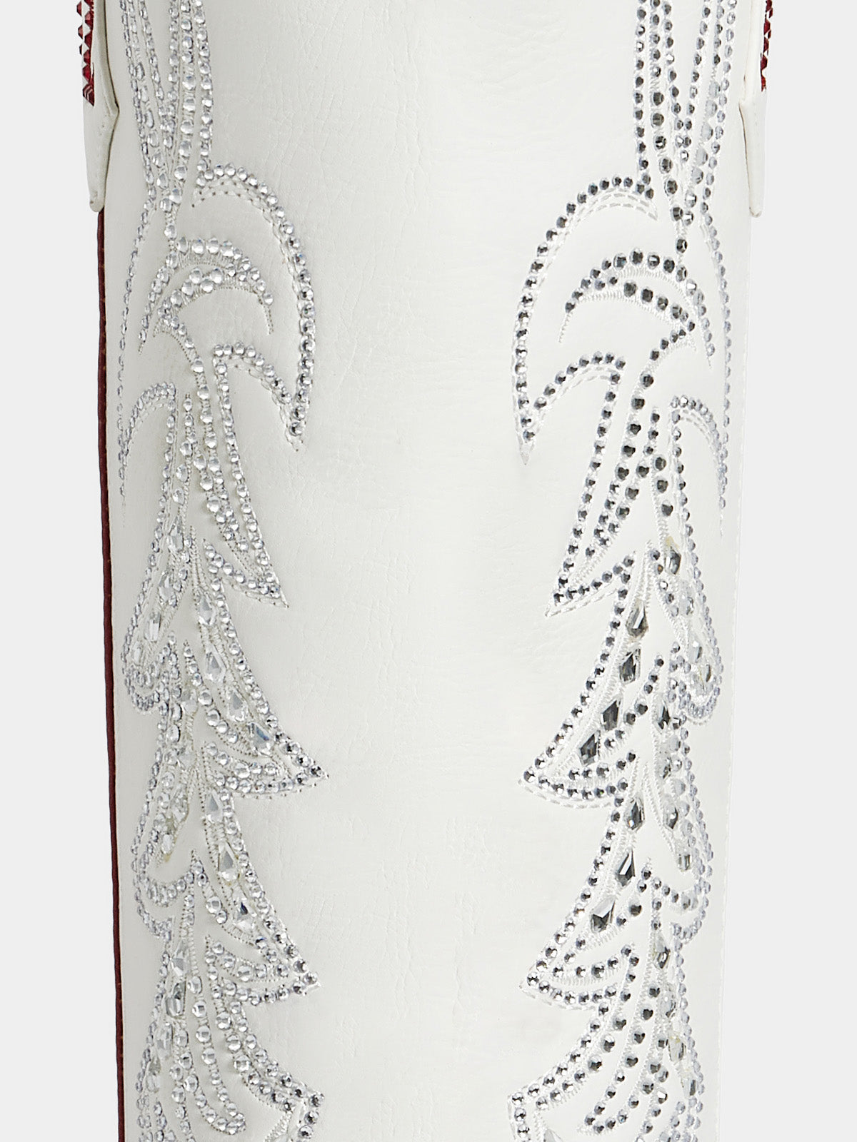 Close-up of a white western boot featuring intricate silver rhinestone embroidery on the shaft.