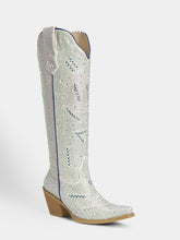 A single knee-high western boot covered in silver rhinestones with blue accents and a tan block heel, shown against a light gray background.