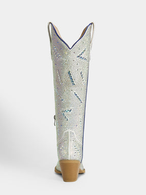 A single cowboy boot shown from the back, featuring a textured silver and white snakeskin pattern with blue accents, a brown stacked heel, and a light tan pull-on sole, set against a plain light gray background.