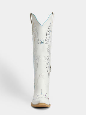 A single white cowboy boot shown from the back, featuring silver rhinestone embroidery, a small blue crown motif near the top, and a tan sole.