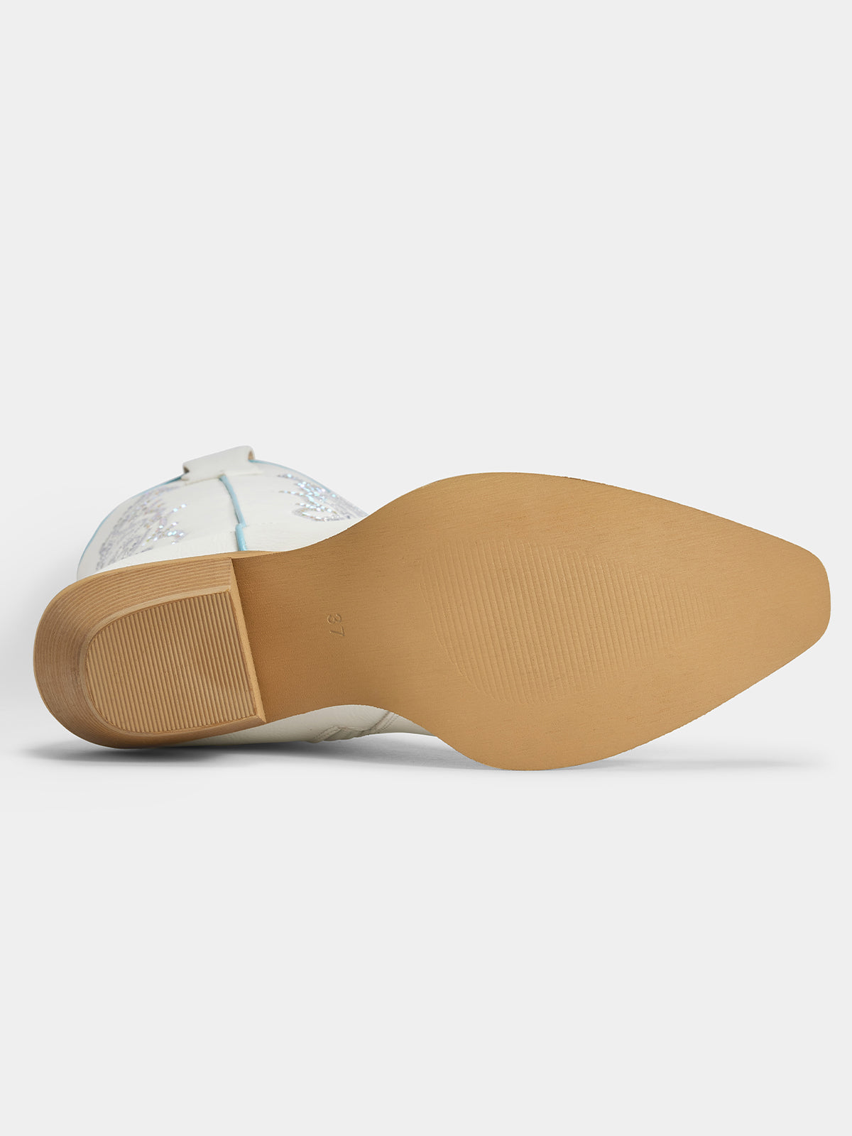 The underside of a cowboy boot showing a tan outsole and a white leather shaft with light blue embroidery, photographed on a light gray background.